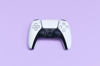 Germany - May 2025: White PlayStation 5 gaming controller on pastel violet background