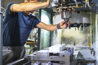 Man working in the machining center for plastic parts using milling cnc machine