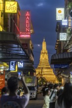 Wat Arun, Temple of Dawn at sunset with dark clouds. Boats on the Chao Phraya river. Tourist