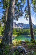 Stunning landscape showing turquoise water of lake carezza with the dolomites in the background on
