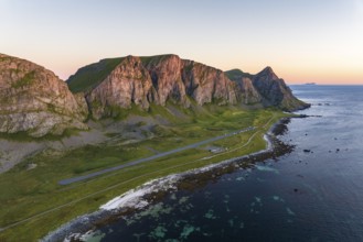 Coast and mountains in the evening light, runway of the abandoned airport, Værøy island, Vaeroy,