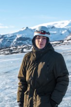 Portrait of an adventurous young man on the Vatnajokull glacier in winter in Iceland