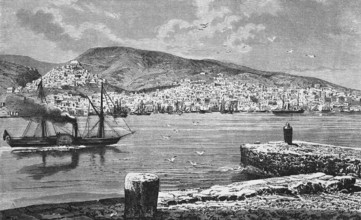 A smoking steamship passes the town of Ermoupoli on the Cyclades island of Syros or Siros, sailing