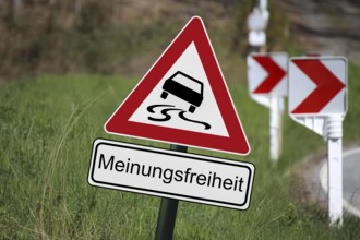 (Photomontage) : Traffic sign with danger of skidding, underneath a sign with the text