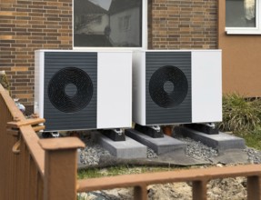 2 heat pumps are installed on an apartment block in a front garden, Hilden, Germany