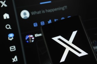 X (twitter) logo is seen on a smartphone, with the bluesky website visible on a computer screen in