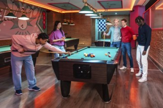 Group of multi ethnic friends enjoying a game of billiards in a vibrant entertainment venue,
