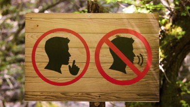 Wooden sign in the forest with symbols indicating peace and tranquillity, Butterfly Valley,