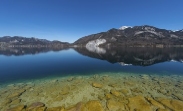 Lake Wolfgang with a reflection of the surrounding mountains, near St. Gilgen, Salzkammergut,