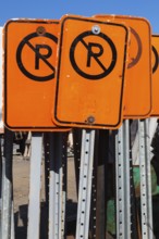 Close-up of fluorescent orange and black No Parking mobile street signs, Quebec, Canada