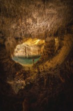 Beautiful view of stalactites and stalagmites surrounding lake martel in caves of drach, mallorca,