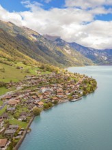 Alpine village on a lake with meadows and autumn colours, framed by mountains, Lake Brienz.