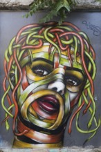 Medusa, female head with hair of colourful snakes, mural in the Anafiotika district, street art,