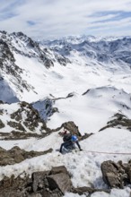 Mountaineer climbing up a steep snow slope, secured by a rope, ascent to the summit of Piz