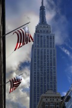 Waving US flag with Empire State Building, New York City, USA