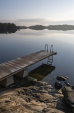 Wooden jetty with ladder, calm water surface, morning atmosphere, Kasnäsintie, Falkö Fjord, Kasnäs,