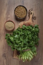 A bunch of fresh cilantro, coriander seeds and powder bowls, close-up, top view, no people, food