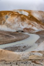 Bridge and steaming streams between colourful rhyolite mountains and snowfields, Hveradalir