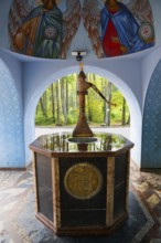 Ornamented fountain in an interior with angel paintings and forest view, Fountain of the Holy