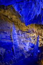 Blue illuminated stalagmites and stalactites in a cave, Devil's Cave Pottenstein, Franconian