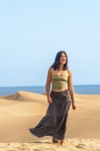 Young woman enjoying a sunny day walking on the maspalomas dunes in gran canaria, spain, expressing