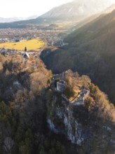 Castle on a rock above a river valley during the golden hour with a gentle hilly landscape in the