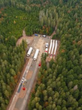 Construction site in the forest with large components and vehicles for the construction of a wind