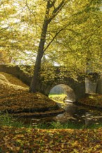 Bridge over the moat in the park of Hermsdorf Castle in autumn, Ottendorf-Ockrilla, Saxony, Germany