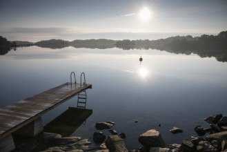 Wooden footbridge with ladder, sun reflected in the sea, morning mood, Kasnäsintie, Falkö Fjord,