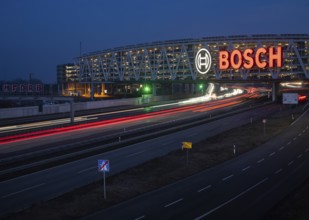 Traffic on the A8 motorway, blue hour, illuminated parking garage, Landesmesse Stuttgart, red-lit