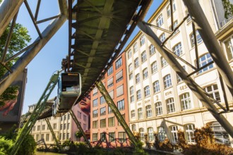 A suspension railway runs between old industrial buildings near the Kluse stop, Wuppertal, Germany