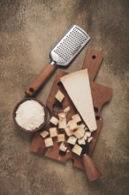 Freshly sliced and grated cheese, parmesan cheese, Gran gusto. Grana padano. on a wooden chopping