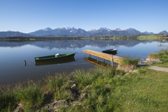 Landscape with green and black boat at a lake, surrounded by mountain peaks, Hopfen am See, near