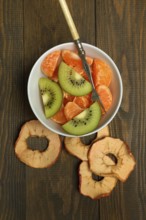 Clementine pieces and kiwi slices in peel, dried apple slices