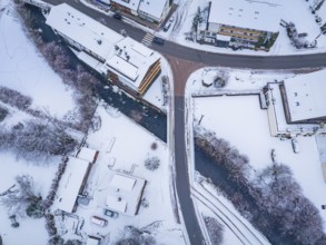 Snowy street view with river and crossing bridge, Enzklösterle, district of Calw, Black Forest,