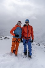 Two ski tourers, couple on the summit of the Köllkuppe or Cima Marmota, snow-covered mountain