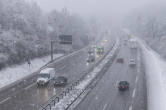 Snow-covered motorway with moving vehicles and snow-covered trees on the roadside, Winnenden,