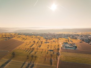 Spacious fields and trees, surrounding a village under bright sunbeams, Neubulach, Black Forest,