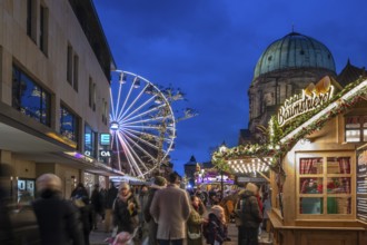 Ferris wheel at the winter village, Christmas market at dusk, St Elisabeth's Church on the right,