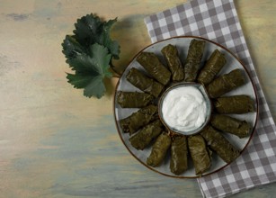 Dolma, cabbage rolls in grape leaves, Traditional Armenian dish, with white sauce, top view,