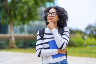 Portrait of a latin young female university student stranding hand on chin and thoughtful
