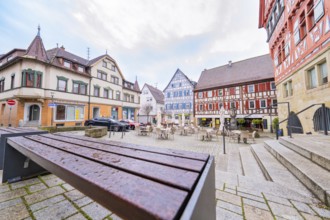 Historic square with colourful half-timbered houses and empty benches, Großbottwar, Ludwigsburg