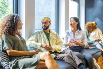 Side view of three coworkers chilling and talking in a comfortable sofa
