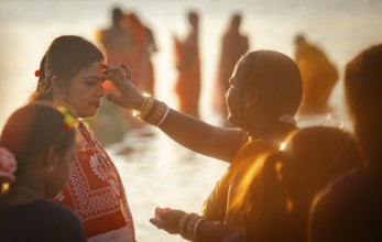 Hindu devotees perform rituals as they offer prayers to the Sun god in the bank of Brahmaputra