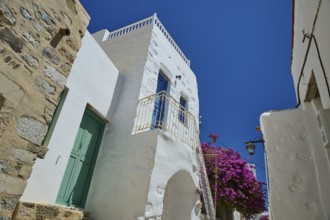 Traditional building with white walls and flowers under a bright blue sky, Chora, Astypalea,