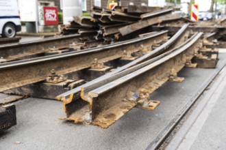 Construction site of a tram line, tracks and railway sleepers are being replaced and lie stacked on