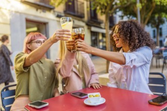 Happy three happy deverse woman toasting in an outdoor bar