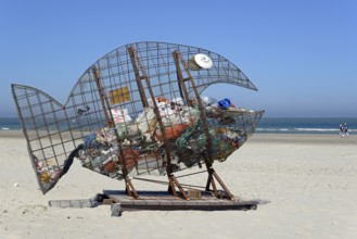 Wire sculpture as a rubbish bin on the sandy beach of Norderney, North Sea, East Frisian Islands,