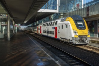 Passenger train at empty platform in the Gent-Sint-Pieters railway station in Ghent during public