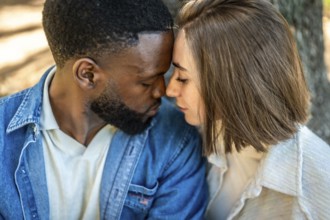 Close up of a beautiful Mixed-race young couple enjoying each other rubbing roses and embracing in